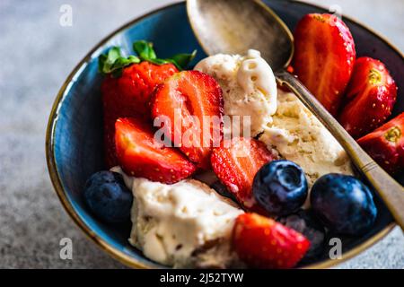 Schüssel Vanilleeis mit frischen Heidelbeeren und Erdbeeren Stockfoto
