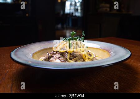 Kartoffelpuffer mit Fleisch in Sauce auf einem Teller. Stockfoto