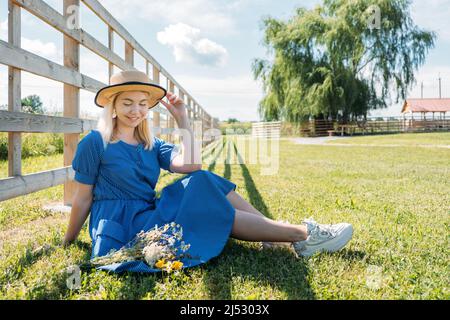 Bauernhöfe und Touren auf dem Bauernhof, Wochenendausflug auf dem Bauernhof Cottagecore. Farm Trips Für Ein Ruhiges Wochenende. Eine Frau in rustikalem Kleid und mit Wildblumen vor Stockfoto