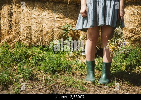 Bauernhöfe und Touren auf dem Bauernhof, Wochenendausflug auf dem Bauernhof Cottagecore. Farm Trips Für Ein Ruhiges Wochenende. Eine Frau in rustikalem Kleid und mit Wildblumen vor Stockfoto