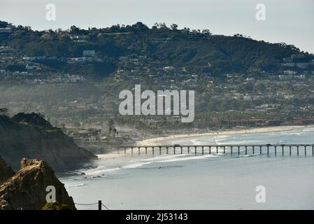 Blick vom morgendlichen Sonnenlicht, das bei Ebbe die Stadt und den Pazifischen Ozean trifft, Scripps Pier, der in das Meeresschutzgebiet La Jolla, Kalifornien, USA, ragt Stockfoto
