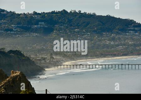 Blick vom morgendlichen Sonnenlicht, das bei Ebbe die Stadt und den Pazifischen Ozean trifft, Scripps Pier, der in das Meeresschutzgebiet La Jolla, Kalifornien, USA, ragt Stockfoto