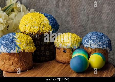 Köstliche Osterkuchen auf einem Holztisch mit Blumen im Hintergrund. Ort für Text. Selektiver Fokus Stockfoto