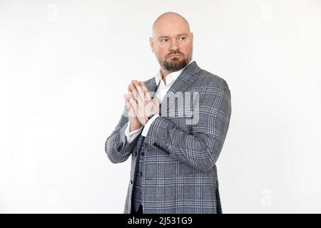 Porträt eines ernsthaften Geschäftsmannes mittleren Alters in grauer karierter Jacke, Weste, weißem Hemd, stehenden, zusammenklappbaren Händen. Stockfoto