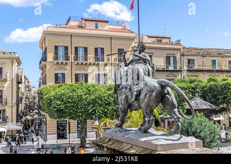 Die Bronzestatue eines Löwen, montiert von einer weiblichen Figur, die ein Horn spielt, vor dem Teatro Massimo in Palermo, Sizilien, Italien. Bildhauer Mario Rutelli. Stockfoto