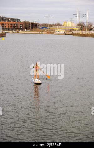 Danzig Polen März 2022 Gruppe von Sup-Surfern stehen auf Paddle-Board, Frauen stehen auf Paddeln zusammen in der Stadt Motlawa Fluss und Kanal in der Altstadt Danzig Polen. Tourismusattraktion Aktive Erholung im Freien Soziale Distanzierung Reiseziele Stockfoto