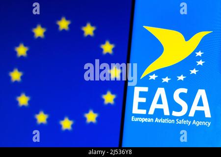 In dieser Abbildung ist das Logo der Europäischen Agentur für Flugsicherheit (EASA) auf einem Smartphone und im Hintergrund die Flagge der Europäischen Union (EU) zu sehen. Stockfoto