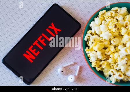 Brasilien. 19. April 2022. In dieser Fotolabbildung wird das Netflix-Logo auf einem Smartphone zusammen mit einer Schüssel Popcorn und Kopfhörern angezeigt. (Foto von Rafael Henrique/SOPA Images/Sipa USA) Quelle: SIPA USA/Alamy Live News Stockfoto