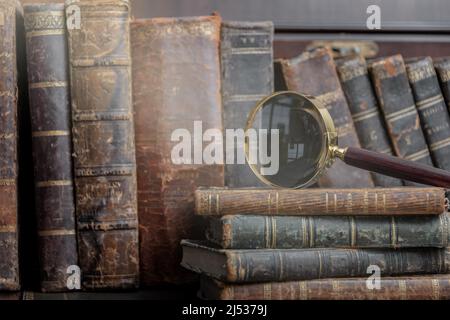 Vintage Buch und Lupe auf Holzhintergrund. Stockfoto
