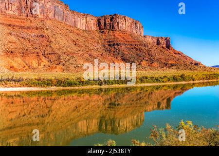 Sandy Beach Access Colorado River Red Rock Canyon Reflection Green Grass Moab Utah USA Southwest. Stockfoto