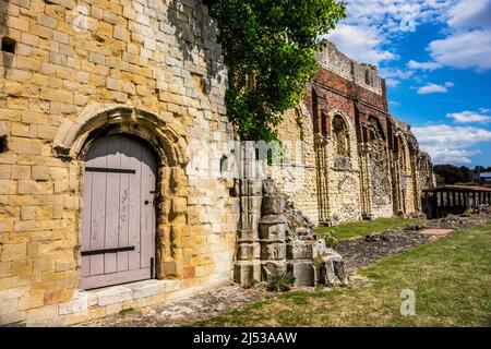 Eingang in die Wand der Kirche der Heiligen Peter und Paul mit dem Königspalast hinter der St. Augustine’s Abbey in Canterbury, England. Stockfoto