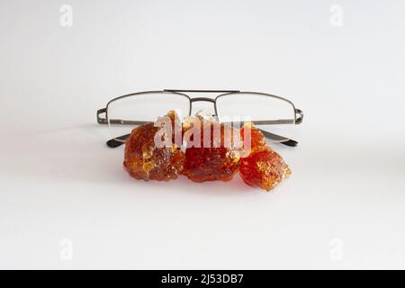 Gummi arabisch vor der Brille Größenvergleich Stockfoto