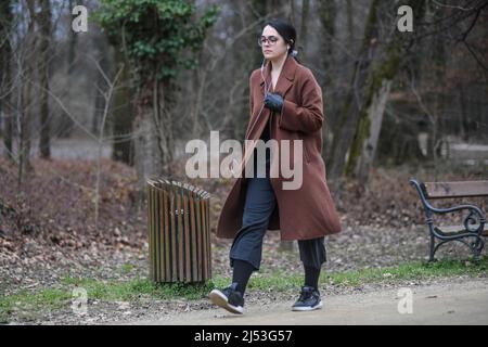 Junge Frau, die im Winter alleine im Maksimir Park spazieren geht. Zagreb, Kroatien Stockfoto