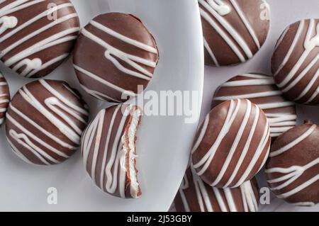 Runde Minzschokolade auf einem weißen Teller auf einem weißen Tisch, Draufsicht über den Kopf oder flache Schussaufnahme Stockfoto