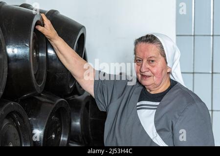 Mallersdorf Pfaffenberg, Deutschland. 14. April 2022. Schwester Doris, Braumeisterin und Nonne im Kloster Mallersdorf, steht neben Bierkegs in der Klosterbrauerei. Quelle: Armin Weigel/dpa/Alamy Live News Stockfoto