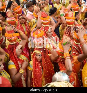 Neu Delhi, Indien April 03 2022 - Frauen mit Kalash am Kopf während des Jagannath-Tempels Mangal Kalash Yatra tragen indische Hindu-Anhänger irdische Töpfe Conta Stockfoto