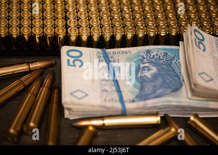 Unter den Patronen befindet sich ein Paket von Papierrechnungen mit einer Stückelung von fünfzig Zloty. Stockfoto