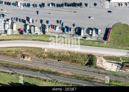 Parkplatz in der Nähe des Bauernmarktes in Vorstadtbereich entlang der Eisenbahn. Luftaufnahme von oben. Stockfoto