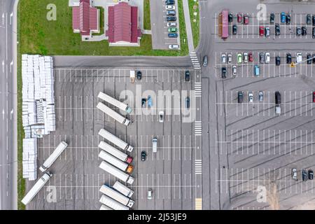 Halb leerer Parkplatz in der Nähe von Einkaufszentrum oder Bauernmarkt. Luftaufnahme von oben. Stockfoto