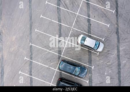 Luftaufnahme von oben auf Autos und Lastwagen, die auf einem Parkplatz in der Nähe des Bauernmarktes stehen Stockfoto
