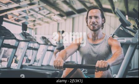 Fitness-Mann trainiert auf dem Rudergerät im Fitnessstudio Stockfoto