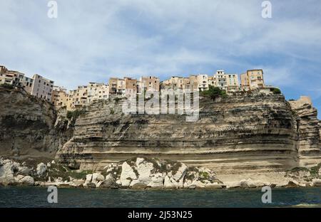 Häuser auf einer Klippe mit Blick auf das Meer des Dorfes BONIFACIO auf der französischen Insel Korsika vom Meer aus gesehen Stockfoto