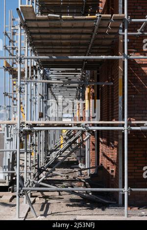 Gerüste auf einer Baustelle einer Reihe neuer Häuser, die gebaut werden sollen. Gerüstmast-Plattform in den Niederlanden Stockfoto