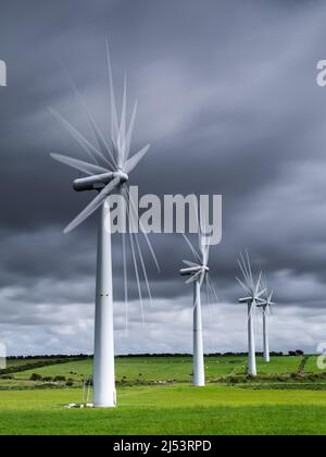 Mehrfache Exposition der Windenergieanlage, die eine Blattbewegung gegen einen stürmischen Himmel zeigt Stockfoto