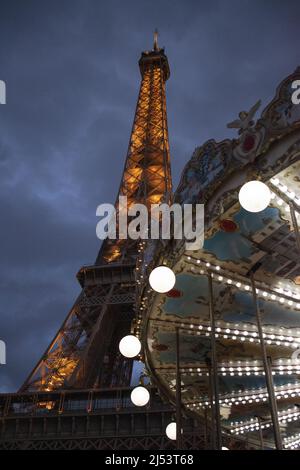 Paris, Frankreich, Europa: Der Eiffelturm Nachts gesehen mit dem Eiffelturm-Karussell, einem Vintage-Karussell im 1900s-Stil Stockfoto