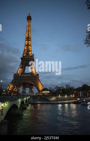 Paris, Frankreich: Der Eiffelturm, ein Metallturm, der 1889 für die Weltausstellung fertiggestellt wurde und nachts von der Brücke Pont d’Iéna beleuchtet wurde Stockfoto