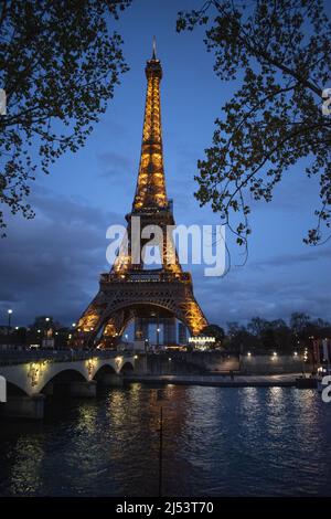 Paris, Frankreich: Der Eiffelturm, ein Metallturm, der 1889 für die Weltausstellung fertiggestellt wurde und nachts von der Brücke Pont d’Iéna beleuchtet wurde Stockfoto