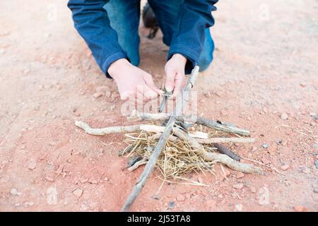 Ein Feuer mit einem Feuerstahl, Überlebens- und Abenteuerausrüstung, Outdoor-Fähigkeiten, Mann, der ein Lagerfeuer macht Stockfoto