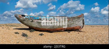 Ein altes verfallenes, verlassene Fischerboot aus Holz an einem Kiesstrand Stockfoto