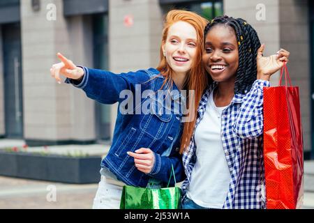 Zwei beste Freunde halten Einkaufstaschen und warten Taxi Stockfoto