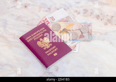 Ureope Union und Polnischer biometrischer Reisepass (Unia Europejska Rzeczpospolita Polska) mit georgischen Lari (GEL)-Banknoten und Münzen auf dem Tisch. Stockfoto