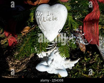 Engelskulptur mit Kopf, der nachdenklich in die Ferne blickt. Grabschmuck auf einem Friedhof Stockfoto