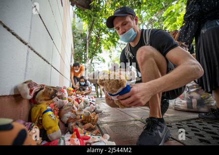 Bangkok, Thailand. 20. April 2022. Ein Mann stapelt ausgestopfte Tiere, um die Kinder zu repräsentieren, die während der Demonstration Opfer des Krieges in der Ukraine wurden. Demonstranten versammelten sich in der Nähe der russischen Botschaft in Bangkok, um ihre Opposition gegen den russischen Krieg in der Ukraine auszudrücken. Thailand ist in Bezug auf den Krieg in der Ukraine offiziell neutral geblieben, nachdem es sich bei der UN-Resolution, die den Krieg Anfang März 2022 verurteilte, der Stimme enthalten hatte. Kredit: SOPA Images Limited/Alamy Live Nachrichten Stockfoto