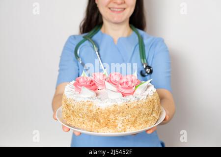 Der Arzt oder die Krankenschwester hält einen großen Geburtstagskuchen, herzlichen Glückwunsch zum Tag des Arztes oder der Krankenschwester Stockfoto