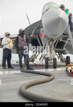Matrosen, die der USS Gerald R. Ford (CVN 78) und dem Carrier Air Wing (CVW) 8 zugewiesen wurden, tanken eine F/A-18F Super Hornet, die an den 'Blacklions' des Strike Fighter Squadron (VFA) 213 befestigt ist, auf dem Flugdeck, 16. April 2022. Ford ist im Atlantik unterwegs und führt im Rahmen der maßgeschneiderten Grundphase des Schiffes vor dem operativen Einsatz die Qualifikation der Frachtführer und die Integration der Streikgruppe durch. (USA Navy Foto von Mass Communication Specialist 2. Class Nolan Pennington) Stockfoto