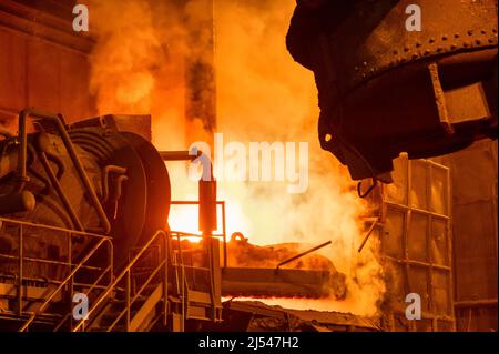 Lichtbogenofen während des Betriebs. Viel Rauch und Feuer Stockfoto