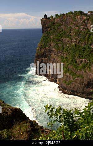 Eine Klippe am Meer mit einem Hindu-Tempel (Pura Luhur/Luhur-Tempel), der auf ihm in Uluwatu, Badung, Bali, Indonesien, errichtet wird. Stockfoto