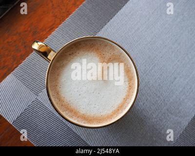 Nahaufnahme einer Tasse Kaffee von oben, die Latte-Kunst in Form eines Herzens zeigt Stockfoto