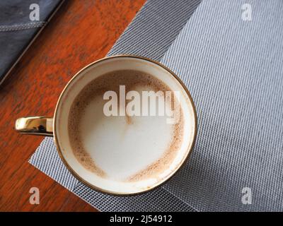 Nahaufnahme einer Tasse Kaffee von oben, die Latte-Kunst in Form eines Herzens zeigt Stockfoto