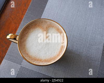 Nahaufnahme einer Tasse Kaffee von oben, die Latte-Kunst in Form eines Herzens zeigt Stockfoto