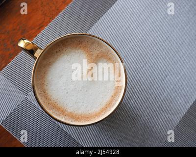 Nahaufnahme einer Tasse Kaffee von oben, die Latte-Kunst in Form eines Herzens zeigt Stockfoto