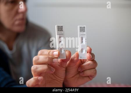 Zwei Corona-Schnellantigen-Tests, ein Positib-Test ein negativer Coronavirus (COVID-19), Schnelllateral-Flow-Tests bei häuslichem selektivem Fokus Stockfoto