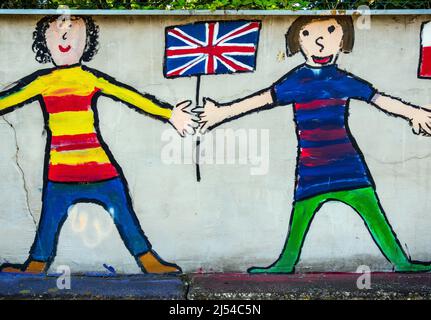 Kinder halten britische Flagge, Graffiti an einer Wand Stockfoto