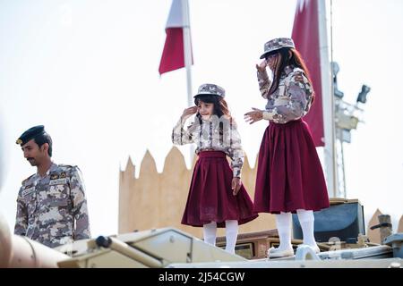 Doha, Katar, Dezember 18,2019. Katarische Kinder in traditioneller und militärischer Kleidung für den Nationalfeiertag. Stockfoto