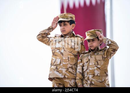 Doha, Katar, Dezember 18,2019. Katarische Kinder in traditioneller und militärischer Kleidung für den Nationalfeiertag. Stockfoto