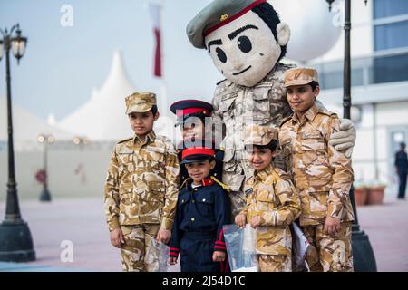 Doha, Katar, Dezember 18,2019. Katarische Kinder in traditioneller und militärischer Kleidung für den Nationalfeiertag. Stockfoto